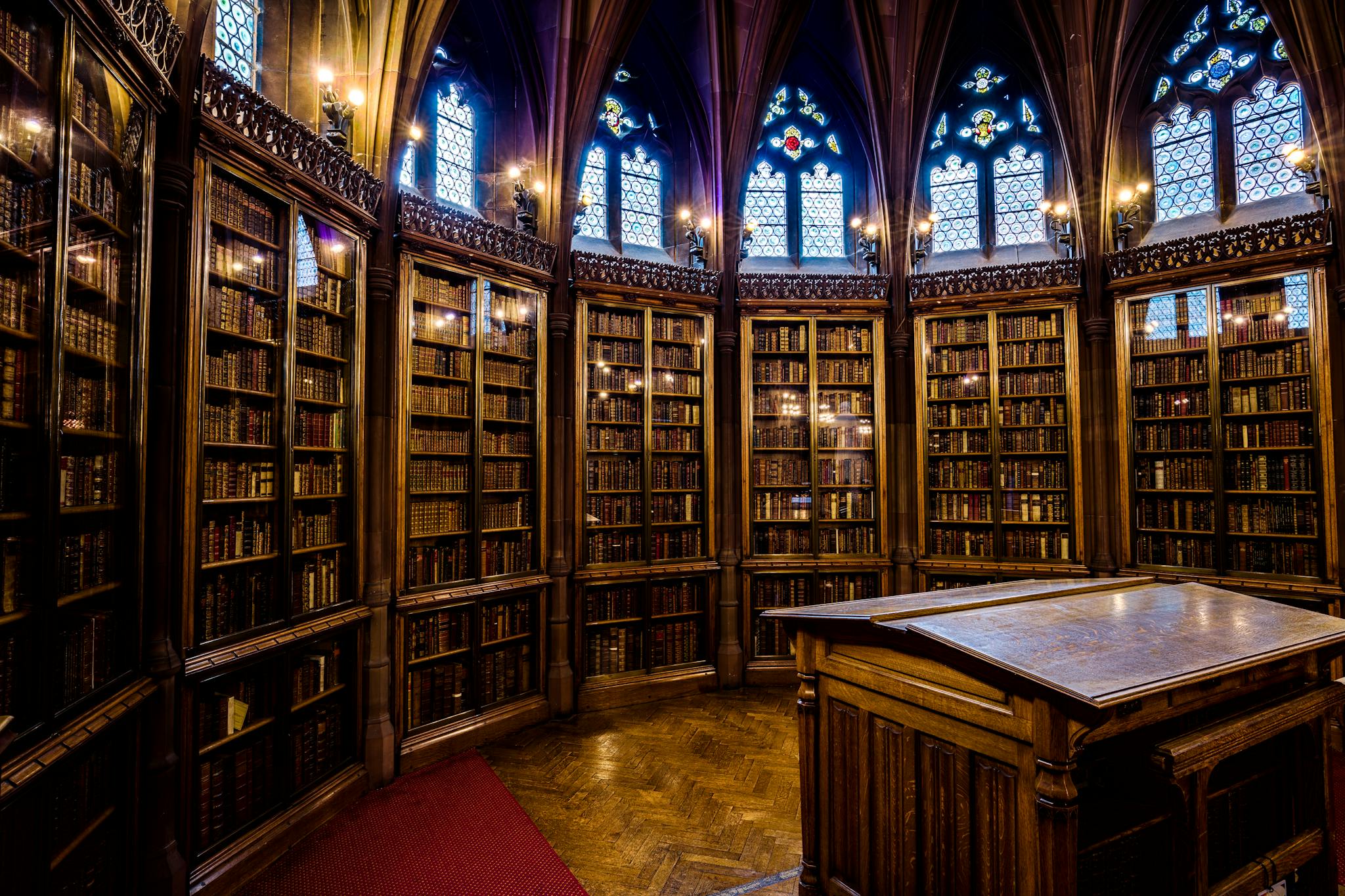 Intricate gothic architecture in a historic library room filled with bookshelves in England.